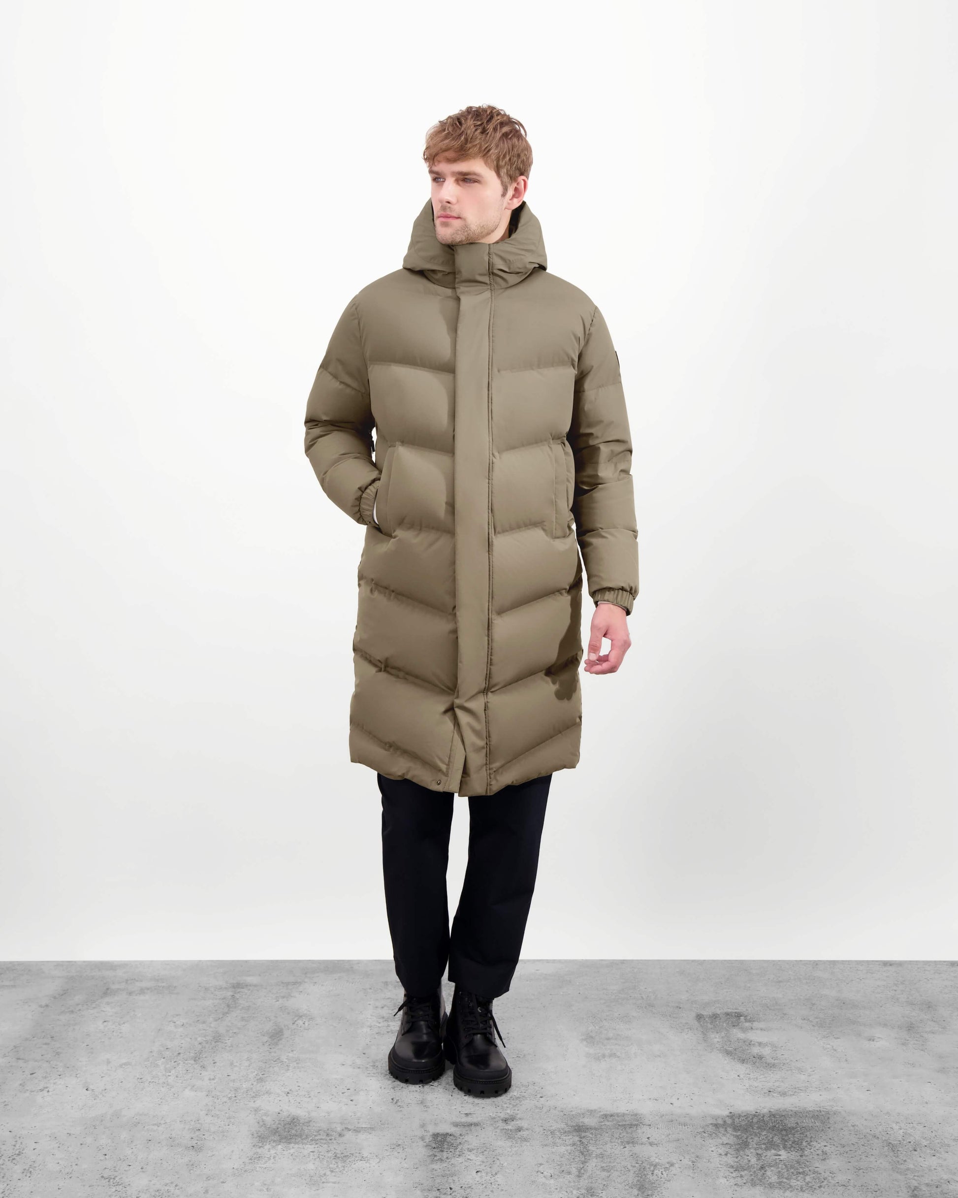 Granger long jacket in Bungee Cord stretch ripstop fabric with DWR coating, insulated with Canadian white duck down and Primaloft. Features a two-way zipper, magnetic closure, and adjustable cuffs for warmth and weather protection.