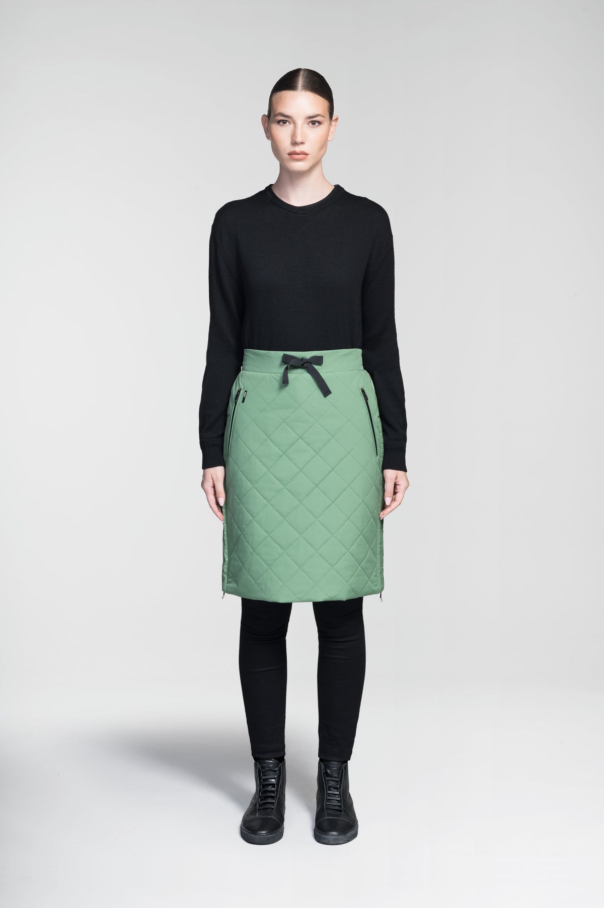 Phora Women's Tailored Skirt in knee length, premium stretch ripstop and contrast cire technical nylon taffeta fabrication, premium 4-way stretch, water resistant Primaloft Gold Insulation Active+, elasticated waistband with grosgrain ribbon drawstrings, two zipper pockets at waist, and zipper closure gusset at side seams, in Comfrey