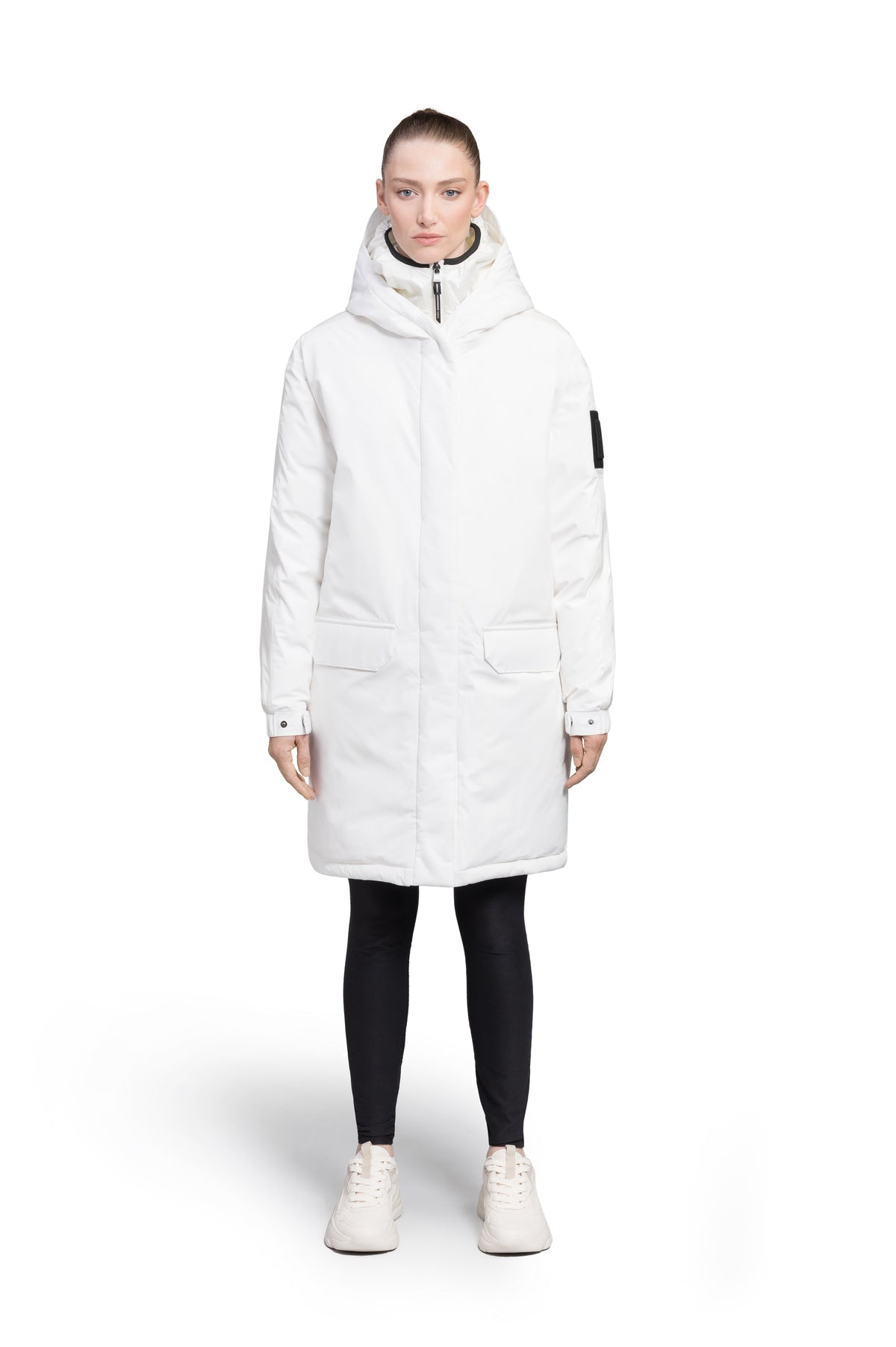 Slyn Women's Performance Parka in thigh length, premium 3-ply micro denier and cire technical nylon taffeta fabrication, Premium Canadian origin White Duck Down insulation, non-removable down-filled hood, inner hooded gilet, two-way centre-front zipper with magnetic closure wind flap, fleece-lined pockets at chest and waist, pit zipper vents, in Chalk