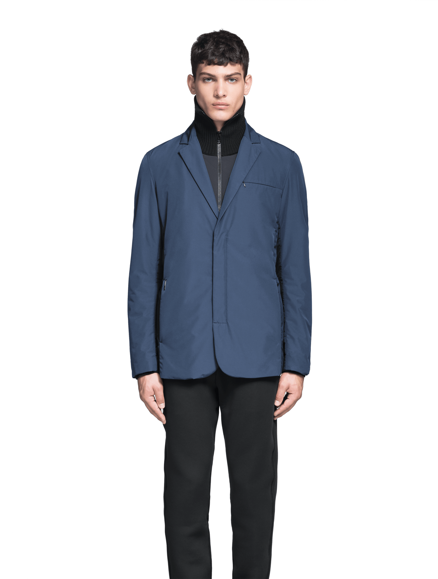 Cody Men's Tailored Travel Blazer in 3-ply micro denier and stretch nylon fabrication with DWR coating, Primaloft Gold Insulation Active+, hidden two-way zipper at centre front with snap closure placket, three invisible exterior zipper pockets, double back pleats, and hidden snap placket at cuffs, in Marine