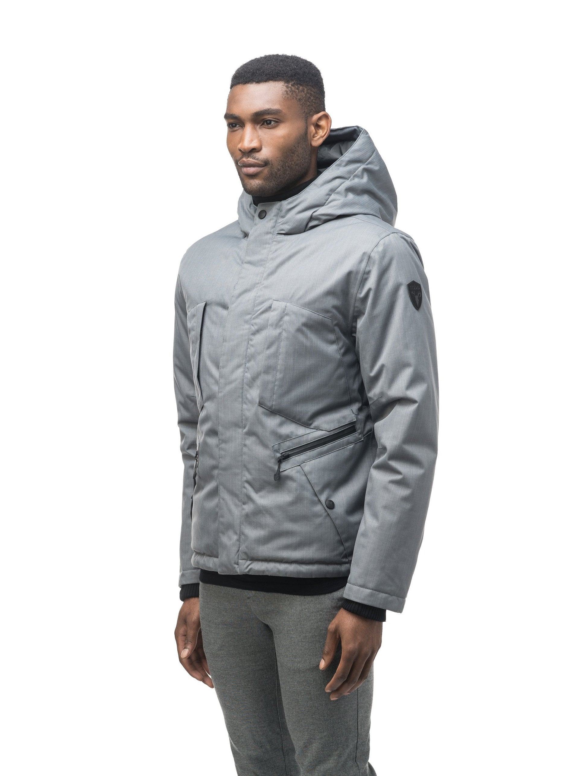 Men's waist length light down coat equipped with six exterior pockets and a hood in Concrete