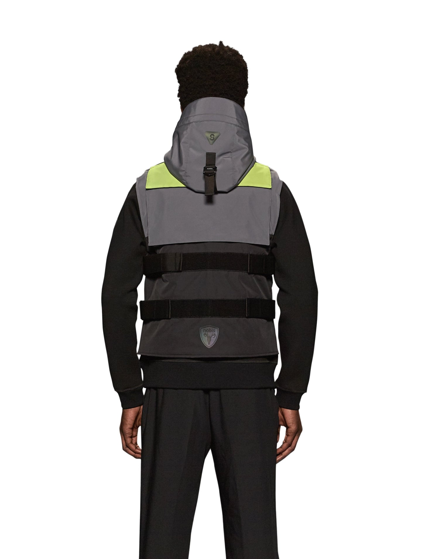 Unisex waist length hooded tactical vest with multiple exterior pockets on front and back, and adjustable side webbing fasteners, colour blocked in Concrete/Black