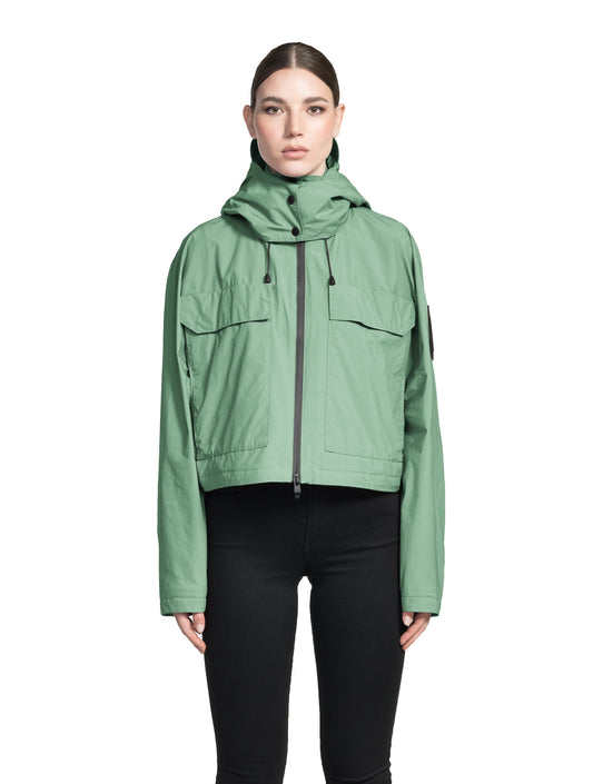 Viva Women's Performance Cropped Jacket in waist length, premium iridescent fabrication, removable hood with peak, adjustable hood draw cords and toggle, 2-way branded zipper at centre front, oversized magnetic closure flap pockets at chest with side entry, interior adjustable draw cord at hem, large interior zipper pocket, and adjustable snap cuffs, in Comfrey